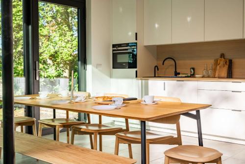 a kitchen with a wooden table and chairs at Glass Forest Cabin Holenduif I Privacy I 3BR Quiet in Oostkamp