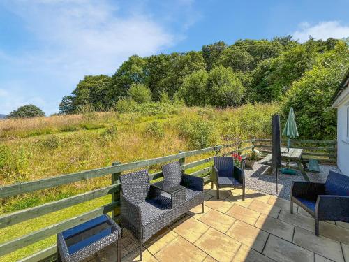 a patio with chairs and a table and a fence at Uk47551 - Cree View Cottage in Newton Stewart