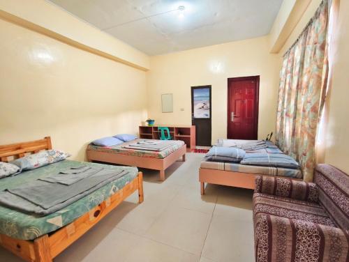 a room with three beds and a couch at Best Sagada Lodge within City Proper! in Sagada