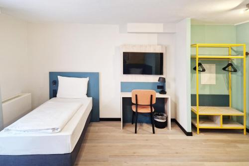 a small room with a bed and a chair at Hotel Boulevard in Stuttgart