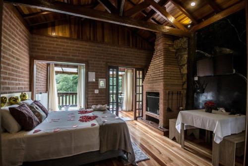a bedroom with a large bed and a fireplace at Chalés Aguas Serenas in Santo Antônio do Pinhal