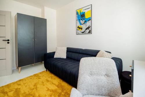 a living room with a blue couch and a cabinet at Apartament Staymonte in Wrocław