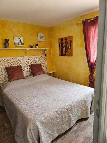 a bedroom with a white bed with a red curtain at 1262 Chemin des Pignatelles in La Motte