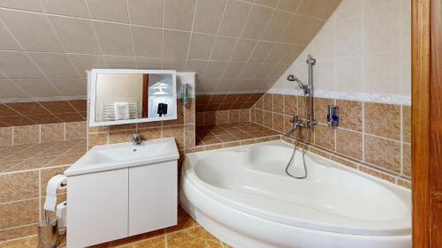 a bathroom with a tub and a toilet and a sink at Pribina Penzión in Nitra