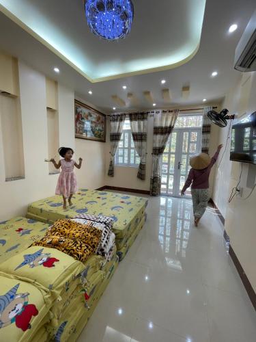 two children jumping on beds in a room at Nhà trọ Hữu Đặng, gần Miếu Bà Chúa Xứ Núi Sam in Chau Doc