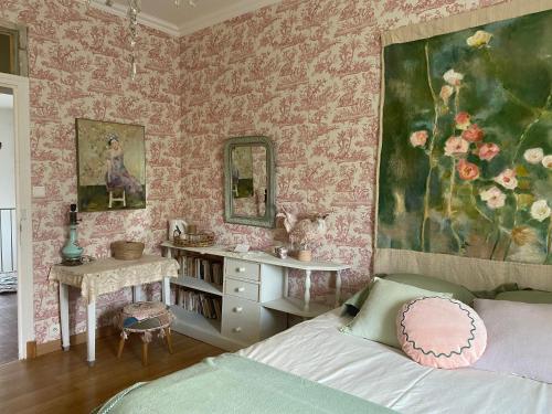 a bedroom with pink wallpaper and a bed and a mirror at Le Rucher des Arts in Alba-la-Romaine