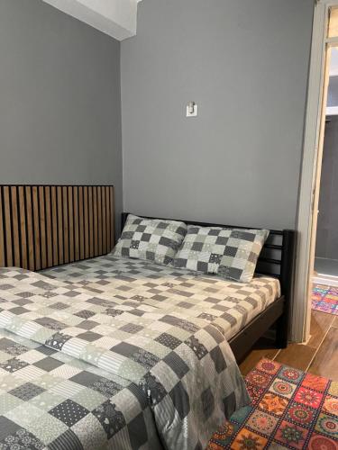 a bedroom with a bed with a checkered blanket at Small House in İzmir