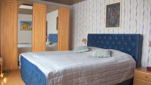 a bedroom with a blue bed with two pillows at Ferienwohnung am Gipsberg in Merzig