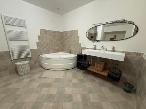 a bathroom with a tub and a sink and a mirror at Case vacanza "LA FORNACE" in Vagliagli