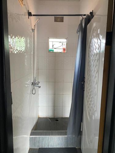 a bathroom with a shower with a shower curtain at Ramachi apartments in Livingstone