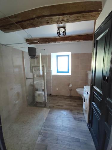 a bathroom with a toilet and a sink and a window at Gîte Le Petit Menhir in Trans