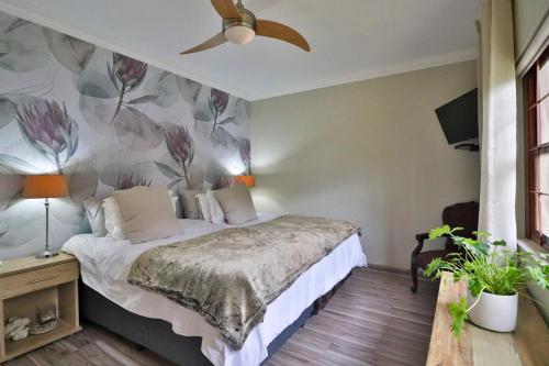 a bedroom with a bed with a flower wallpaper at Panorama View Pool House Steiltes I in Nelspruit