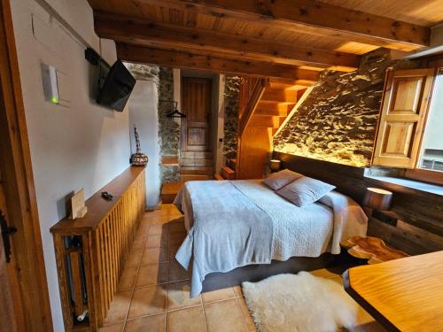 a bedroom with a bed and a tv in a room at Cal Serni in Calbinyà