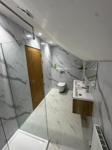 a bathroom with a shower and a sink and a toilet at Crannach House bed and breakfast and self catering apartments in Ballater