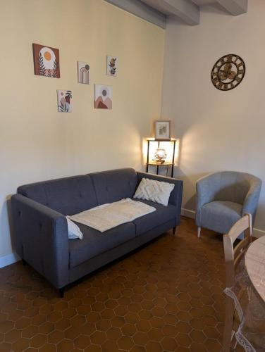 een woonkamer met een blauwe bank en een stoel bij La source in Le Grand-Pressigny