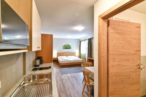 a kitchen with a sink and a bed in a room at Texel Apartments in Madonna