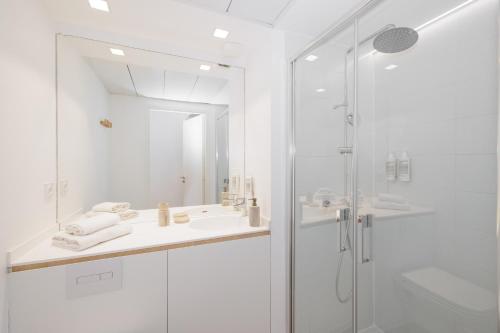 a white bathroom with a shower and a sink at Babel Community Hôtel - Montpellier centre in Montpellier