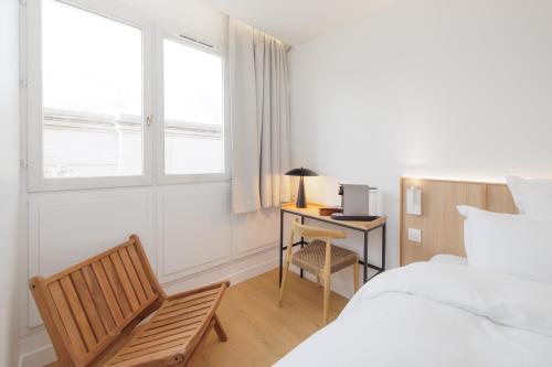 a bedroom with a bed and a chair and a desk at Babel Community Hôtel - Montpellier centre in Montpellier