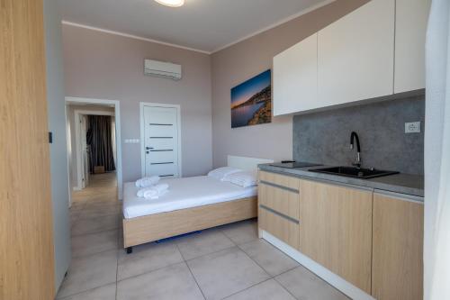 a small bedroom with a bed and a sink at Wind Rose Bura-beachfront in Igrane