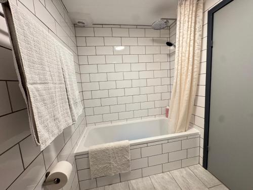 a white bathroom with a tub and a shower at Brand New Charming Nordic Home for 6 - Near Copenhagen in Farum
