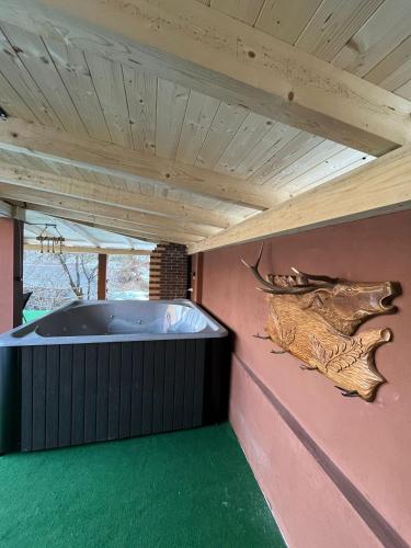 a jacuzzi tub in a pink wall with a wooden ceiling at Cabana Bianca & Iair in Poiana Vadului