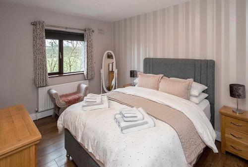 a bedroom with a large bed with two towels on it at Sleepy Rock in Dungarvan
