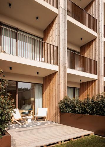 an external view of a building with a wooden deck at Aethos Hotel Ericeira in Ericeira
