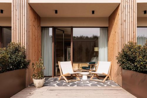 a pair of chairs and a table on a patio at Aethos Hotel Ericeira in Ericeira