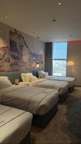 a row of beds in a room with a mural at فندق جولدن نيو سمارت لاكجري - Golden New Smart Hoteluxury in Abha