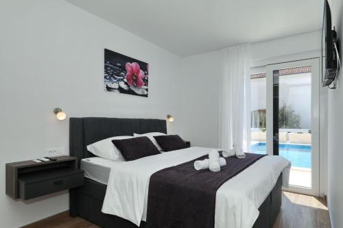 a bedroom with a large bed and a pool at Mariva in Vir