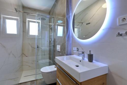 a white bathroom with a sink and a shower at Mariva in Vir