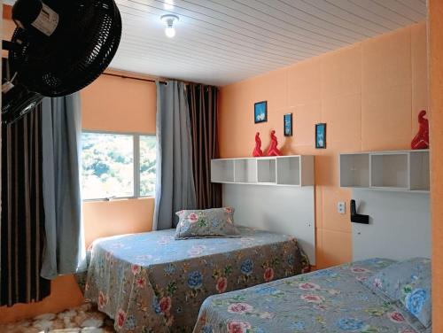 a bedroom with two beds and a window at Pousada Opção I in Triunfo
