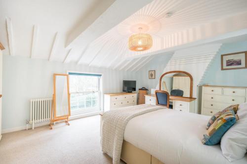 a bedroom with a bed and a dresser and a window at The Old Bakery, Wrentham in Wrentham
