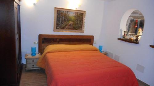 a bedroom with a bed with a orange bedspread at Le Petit Soleil in Saint-Christophe