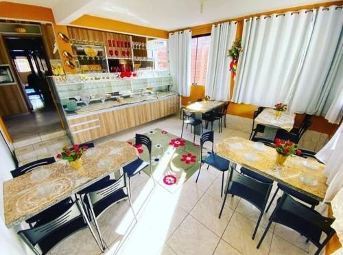 a restaurant with tables and chairs and a counter at Pousada Opção I in Triunfo