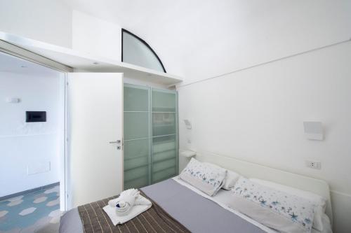 a small bedroom with a bed and a glass wall at La mia casetta al mare in Minori
