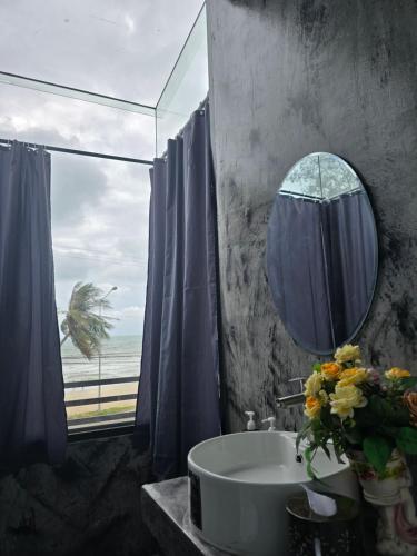 a bathroom with a sink and a mirror and a window at โรงแรมเลทุ่งแล่น 109 in Ban Phru Ching (1)