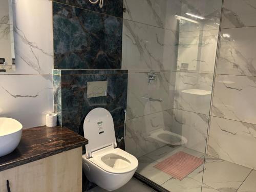 a bathroom with a toilet and a glass shower at Golden Heights in Dehradun