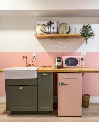 a kitchen with a sink and a microwave at Abode Beach House in Clearwater Beach