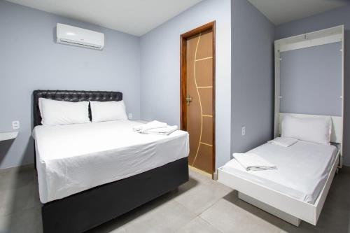 a small room with two beds and a window at Pousada Recanto do Sol BF in Baía Formosa