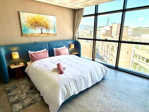 a bedroom with a large bed with a large window at Studio luxueux avec vue panoramique sur le centre ville in Fez