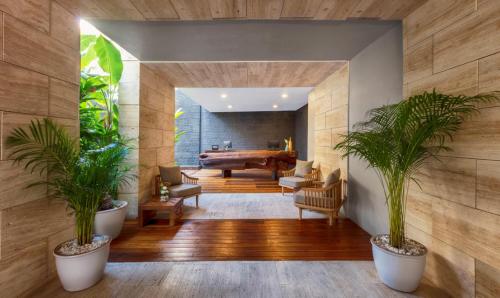 a living room with a pool table and two potted plants at The Yucatan Playa Del Carmen, Tapestry Collection By Hilton in Playa del Carmen
