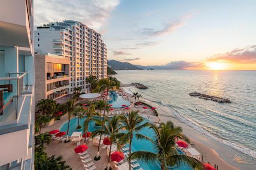 an aerial view of a hotel and the beach at sunset at Hilton Vallarta Riviera All-Inclusive Resort,Puerto Vallarta in Puerto Vallarta