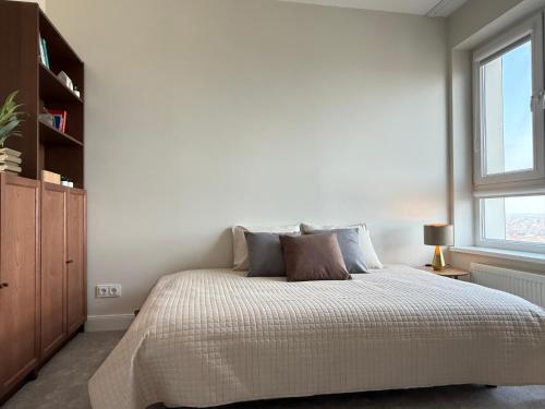 a bedroom with a large bed and a window at Bird's eye Apartment with sea view 18th floor in Klaipėda