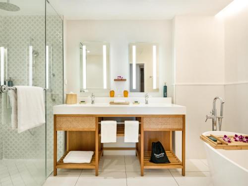 a bathroom with a sink and a shower at Hilton Hotel Tahiti in Papeete