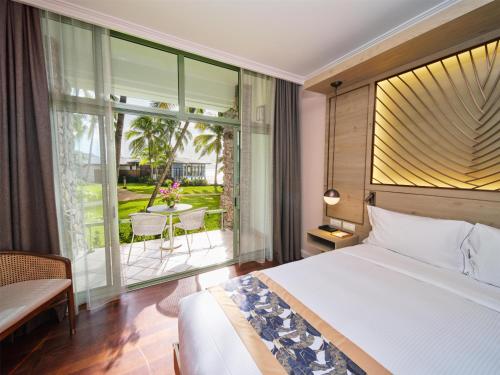a bedroom with a bed and a view of a patio at Hilton Hotel Tahiti in Papeete