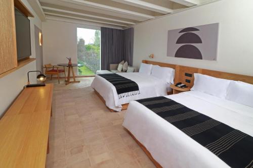 a hotel room with two beds and a table at Albor San Miguel de Allende, Tapestry Collection by Hilton in San Miguel de Allende