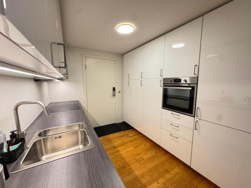 a kitchen with a sink and a stove top oven at Brand New Charming Nordic Home for 6 - Near Copenhagen in Farum
