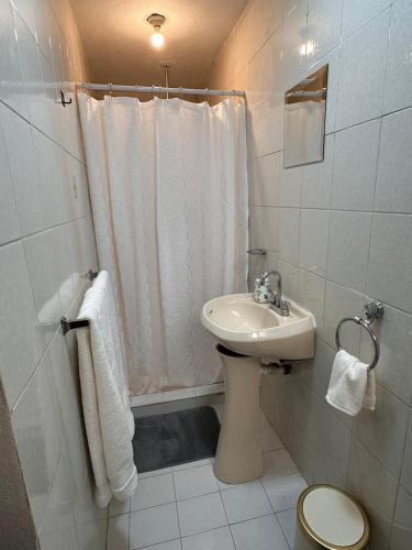 a white bathroom with a sink and a toilet at Casa Homero 23 in Morelia