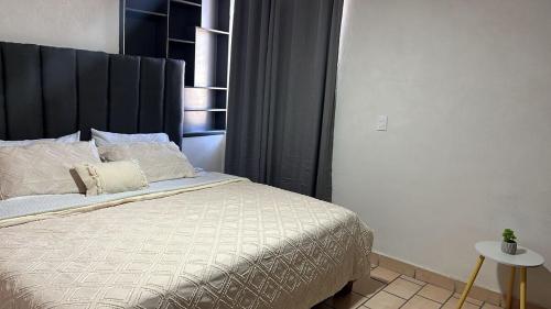 a bedroom with a bed with a black headboard at Casa Homero 23 in Morelia